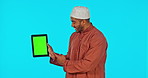 Green screen, tablet and Muslim man showing chromakey on a device feeling happy and isolated in a studio blue background. Thumbs up, excited and portrait of male approve and accept internet deal