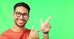 Face, space and pointing with a man on a green screen background in studio for marketing or product placement. Portrait, hand gesture or advertising with a handsome young male in glasses on chromakey