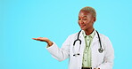 Doctor hand, empty space and isolated on blue background healthcare presentation, mockup or product placement. Yes face of black woman nurse or medical worker, palm and advertising mock up in studio