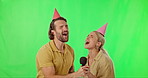 Green screen, party and couple singing karaoke for a birthday celebration isolated in a studio background. Microphone, song and people sing to celebrate together and feeling happy making music