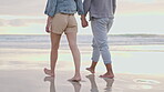 Legs walking, holding hands and a couple at the beach for holiday freedom, love and romance. Sunset, nature and a man and woman with affection on a walk at the sea together on a date or vacation