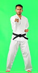 Portrait, karate and screaming with a man on a green screen background in studio for martial arts. Fighting, self defense and shouting with a young male sports athlete striking on chromakey mockup