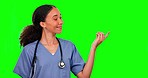 Nurse, green screen and woman pointing to mockup in studio isolated on a background. Face portrait, medical surgeon and happy person with product placement, advertising or doubt, question or shrug.