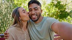 Selfie, love and interracial couple in park kiss for bonding, quality time and relax on weekend date. Relationship, dating and portrait of happy man and woman take picture for memory, post and smile