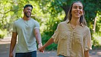 Park, walking date and happy couple holding hands with love and a smile outdoor on summer day. Happiness, nature and walk of a man and woman together for holiday and romance laughing from garden fun