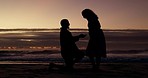 Love, silhouette and couple on a beach,  engagement and relationship with happiness, vacation and support. Dark, man and woman on seaside holiday, proposal and asking for hand in marriage and romance