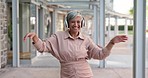 Senior woman with headphones, dancing outdoor and listening to music with freedom in city and travel. Professional female in urban street, carefree and happy with audio streaming playlist and energy