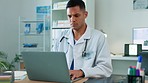 Doctor, man and laptop in cardiology research typing or browsing healthcare results or communication on desk. Male medical professional working on computer for online health search, study or planning