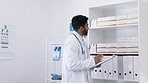 Doctor, man and clipboard for inventory inspection on healthcare supplies, stock or prescription at clinic. Male medical professional checking on pharmaceutical products or checklist at the hospital