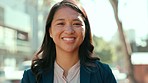 Happy, confidence and face of a businesswoman in the city standing in the street while walking to work. Happiness, smile and portrait of a professional female employee commuting to the office in town