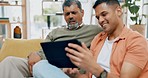 Family, father and adult son with a tablet, couch and connection for social media, internet search and bonding. Love, parent or male person on a sofa, technology or happiness at home and quality time