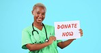 Doctor, donate now sign and black woman on blue background with poster, billboard and banner. Healthcare, medical mockup and portrait of female nurse smile for donation, charity and help on chromakey