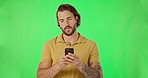 Annoyed, man and phone in green screen studio with bad, signal and poor connection on mockup background. Smartphone, glitch and male frustrated with internet, problem and error or network delay