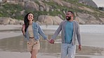 Happy couple, walking and holding hands on the beach for  travel, holiday or weekend together in nature. Man and woman on sunset walk with smile in happiness for bonding relationship on ocean coast