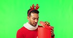Christmas, gift and disappointed man in green screen studio with present on mockup background. Festive, box and unhappy asian male with sad expression, frown and negative emotion, fail and moody