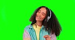 Dancing, green screen and woman with headphones, excited and celebration against studio background. Female person, hipster or dancer with headset, movement and cheerful with radio and streaming music