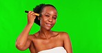 Beauty, makeup and black woman with brush on green screen for facial cosmetics, skincare and happiness. Skin care, smile and happy model with make up tools for cosmetic application tutorial for women