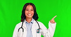 Medical, pointing and a doctor woman on a green screen background to recommend an insurance product. Healthcare, presentation and hand gesture with a young female medicine professional on chromakey