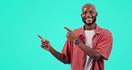 Marketing, advertising and man pointing in a studio with mockup space for product placement. Happy, smile and portrait of an African male model showing mock up with hands isolated by blue background.