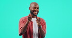 Smile, portrait of man holding gun and against a blue background. Happiness or excited, winning and smile with isolated black male person gesturing shooting weapon with hand against a studio backdrop