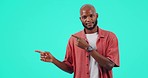 Marketing, pointing and man in studio with mockup space for product placement or advertising. Disagreement, portrait and disappointed African male model showing mock up isolated by a blue background.