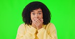 Shock, wtf and face with a woman on a green screen background in studio covering her mouth. News, portrait or omg and a young female person looking shocked and surprised at gossip or an announcement