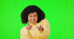Portrait, pointing and motivation with a woman on a green screen background in studio for a choice or selection.  Hands, funny and you with a happy young female person indoor to vote for a decision