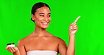 Portrait, cream and pointing with a black woman on a green screen background in studio for beauty. Facial, cosmetics and lotion with a happy young female model indoor to explain steps for skincare