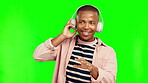 Music headphones, dance and black man on green screen in studio isolated on a background. Radio, listening and happy African person dancing to audio playlist, jazz podcast or streaming hip hop sound.