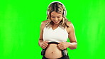 Happy, pregnant woman or headphones on belly in studio for growth or baby development on green screen. Pregnancy music, relax or mother to be streaming radio audio on stomach for healthy maternity 