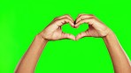 Hands, green screen and heart shape in studio with mockup space for marketing or advertising. Emoji, symbol and closeup of person with love hand gesture isolated by chroma key background with mock up