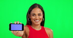 Happy woman, phone and mockup on green screen for advertising against a studio background. Portrait of female person with smile showing mobile smartphone app, chromakey or display on mock up space