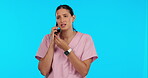 Healthcare communication, time and a woman on a phone call isolated on a blue background in a studio. Stress, medical schedule and a young doctor talking on a mobile with mockup space and a watch