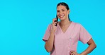 Talking doctor, healthcare and a woman on a phone call isolated on a blue background in a studio. Consulting, communication and a medical employee speaking on a mobile for nursing and medic advice