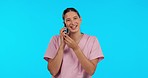 Talking doctor, smile and a woman on a phone call isolated on a blue background in a studio. Consulting, communication and a medical employee speaking on a mobile for nursing and medic advice