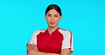 Soccer, focus and arms crossed with a sports woman in studio isolated on a blue background for training. Portrait, football and fitness with a serious young female athlete ready for a game or match
