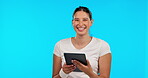 Tablet, research and smile with a woman on a blue background in studio for social media browsing. Portrait, technology and app with a happy young female surfing the internet for online information
