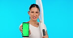 Phone, green screen or tennis with an angry woman on blue background in studio for sports marketing. Portrait, frustrated and fitness with a female athlete holding chromakey mockup on a mobile screen