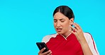 Phone, stress and female athlete in studio looking at football results from a match, tournament or game. Frustrated, technology and upset woman soccer player on cellphone isolated by blue background.