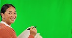 Asian woman, teacher and writing with pen on green screen or mockup for lesson against a studio background. Portrait of happy female person write, drawing or read for question, learning or education
