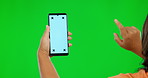 Woman, hands and phone mockup on green screen for social media advertising against a studio background. Hand of female person with smartphone, mock up display and tracking markers for advertisement