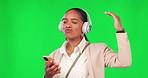 Green screen, woman and dance with music, headphones and phone, happy and fun on mockup background. Radio, earphones and female dancing to podcast on smartphone app, smile and celebrating freedom