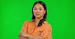 Confident, attitude and arms crossed with an asian woman on a green screen background in studio. Portrait, mindset and pride with a young korean female person standing indoor on chromakey mockup