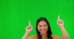 Happy asian woman, pointing and marketing on green screen against studio background. Female person finger point in market advertising, sale discount or deal for notification, alert or news on mockup