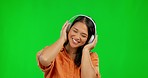 Dance, radio headphones and woman on green screen in studio isolated on a background mockup. Music, listening and happy Asian person streaming audio, sound or podcast, jazz and dancing with energy.