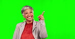Face, pointing and senior woman on green screen in studio isolated on a background. Portrait, happy and business person with hand gesture for mockup, advertising or branding for marketing promotion.