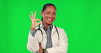 Okay emoji, face and doctor on green screen of healthcare success, support or excellence in services. Happy medical worker or latino woman for helping sign, good job or yes hands on studio background