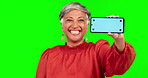 Mockup, phone and portrait of a woman on green screen for announcement, advertising or website. Happy mature person with smartphone and tracking markers in hand for ui, internet or network promotion