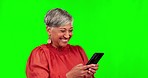 Phone, typing and senior woman on green screen for funny conversation, chatting and social media. Communication, networking and happy female person on smartphone for internet, online message and meme