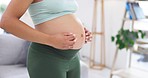Pregnant woman, stomach massage and hands at home with baby love, support and relax care. Female person, healthy belly development and mom with maternity and pregnancy in a house living room
